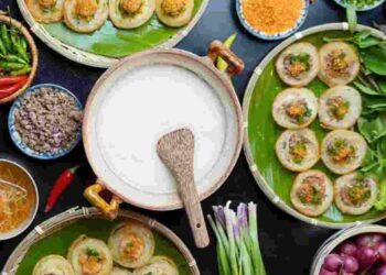 Khay bánh khọt đã hoàn thành với đầy đủ nguyên liệu ăn kèm gồm chanh, hành tây, rau ngò và đặc biệt là rau sống tươi xanh